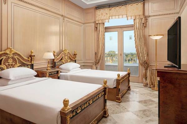 Hotelzimmer im Palm Royale Soma Bay mit zwei Betten, einem Balkon und einer Fernseher.