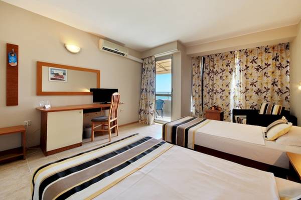 Doppelzimmer im Excelsior Hotel mit zwei Betten, Schreibtisch und Meerblick.