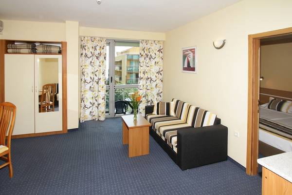 Hotelzimmer im Excelsior Hotel mit Sofa, Tisch, Schrank und Bett.