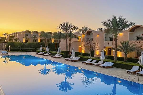 Gemma Resort Poolbereich bei Sonnenuntergang mit Loungeliegen und Palmen