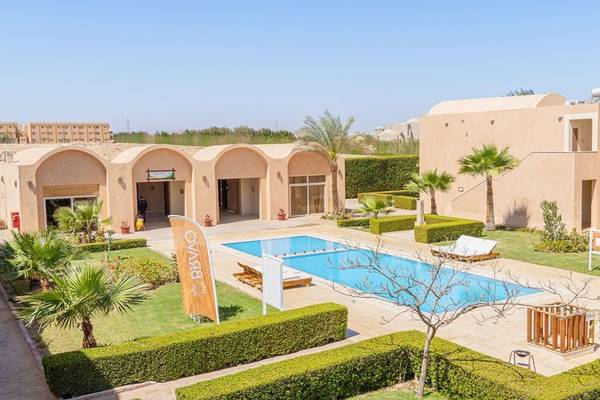 Außenansicht des Gemma Resort mit Swimmingpool und Liegebereichen.