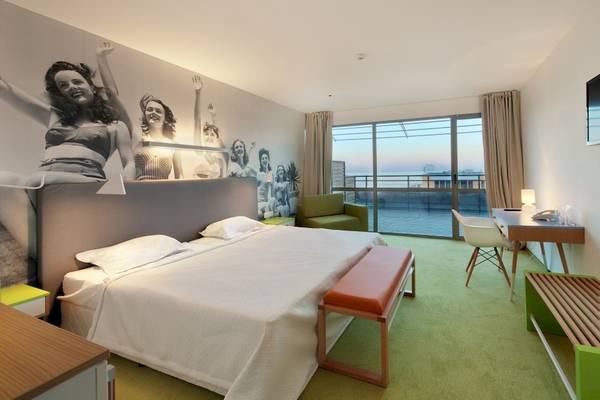 Ein modernes Schlafzimmer im Excelsior Hotel mit grünem Boden und einer großen Wandmalerei.