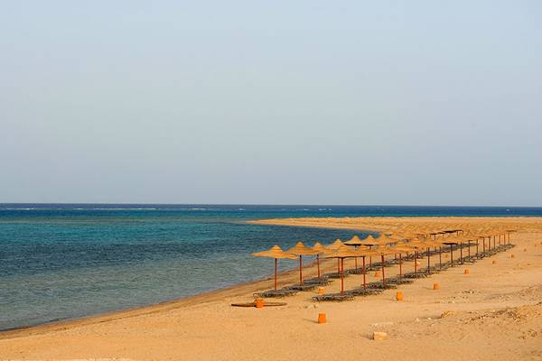 Strand des Gemma Resorts mit vielen Sonnenschirmen und Liegen am Meer