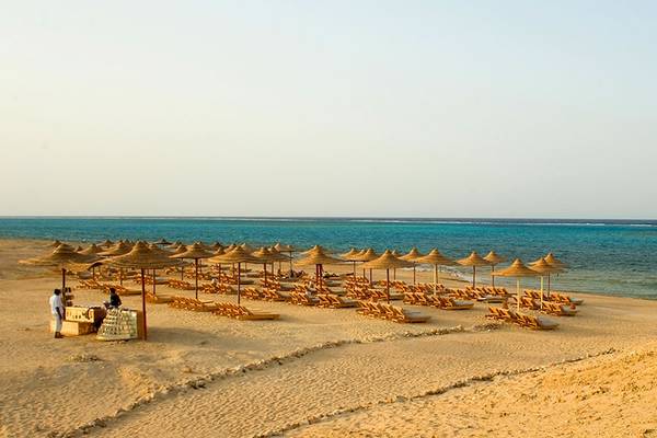 Gemma Resort Strand mit Sonnenliegen und Sonnenhuten am Meer