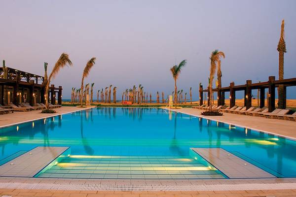 Außenpool des Gemma Resorts bei Abenddämmerung mit Lounge-Sesseln und Palmen