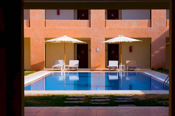 Außenbereich des Gemma Resort mit Pool, Liegen und Sonnenschirmen.