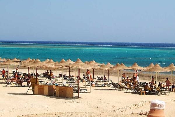 Strand mit Sonnenschirmen und Liegen am Gemma Resort