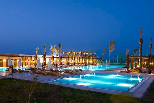 Außenpool des Gemma Resort bei Nacht mit Loungeliegen und Palmen