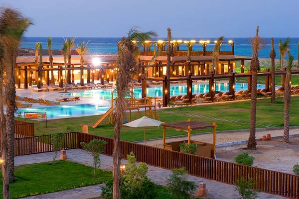 Außenbereich des Gemma Resorts mit Swimmingpool, Sonnenliegen und Palmen.