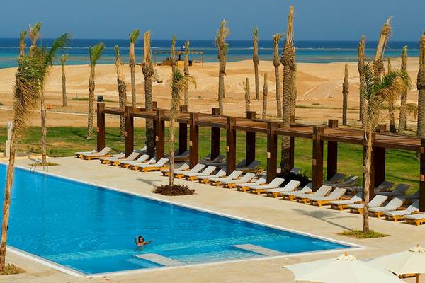 Außenpool mit Liegestühlen und Palmen am Gemma Resort Strand