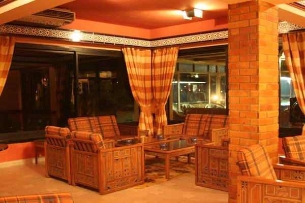 Lobby-Lounge des Mangrove Bay Resorts mit gemusterten Stühlen und Tischen vor einer großen Fensterfront.