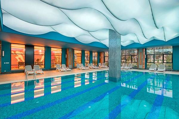 Innenpool des Seaden Valentine Resort & Spa mit blauen Wänden und gewellter Decke.