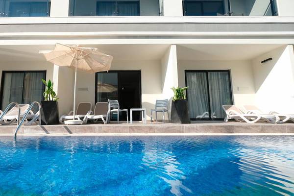 Poolbereich des Seaden Valentine Resort & Spa mit Sonnenschirmen und Liegestühlen.