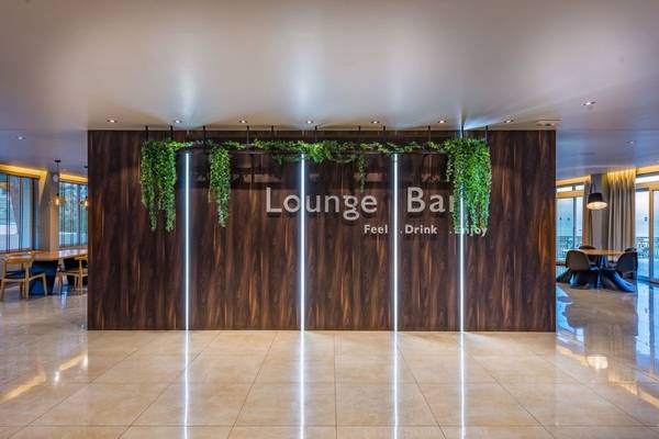 Innenansicht der Lounge Bar im Alexandra Beach Resort mit begrünter Wand und hellem Boden.