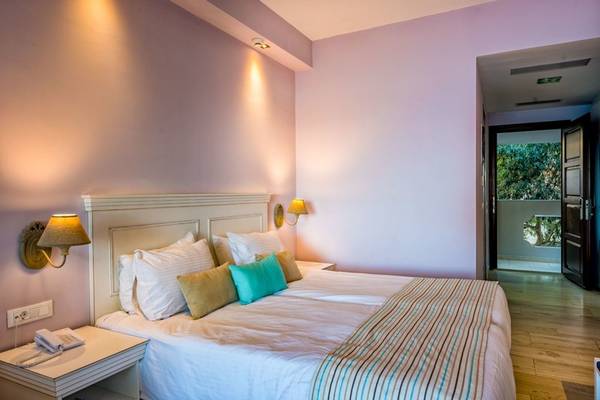 Doppelbett im Schlafzimmer im Alexandra Beach Resort mit Bettwäsche und Kissen.