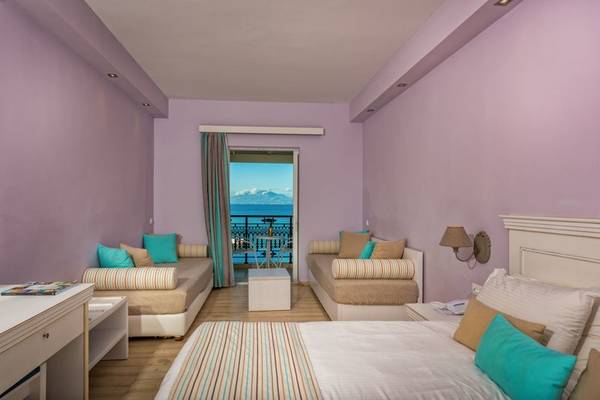 Zimmer im Alexandra Beach Resort mit Blick auf den Balkon und das Meer.