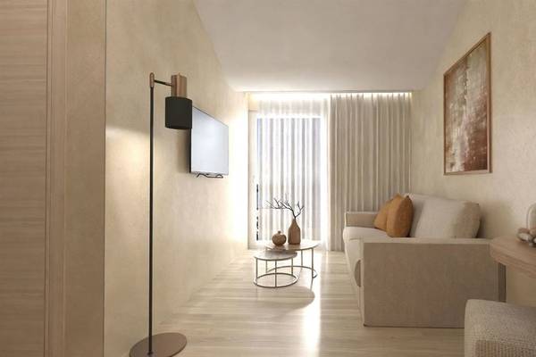 Wohnzimmer im Alexandra Beach Resort mit moderner Einrichtung und offenem Fenster.