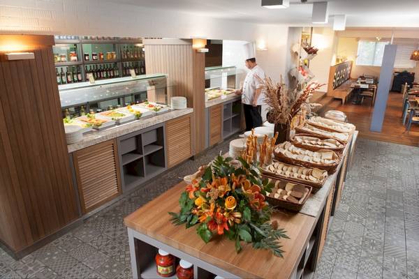 Buffettisch im Excelsior Hotel mit verschiedenen Speisen, Früchten und Dekoration.