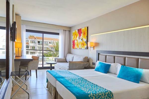 Doppelbett-Zimmer im Fergus Style Bahamas Hotel mit Blick auf eine Terrasse und eine Stadt.