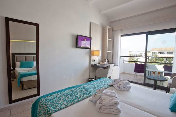 Zimmer im Fergus Style Bahamas Hotel mit Doppelbett, Fernseher und Balkon.