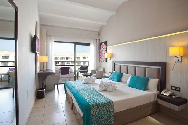 Doppelzimmer im Fergus Style Bahamas Hotel mit Balkon, zwei Betten und modernen Möbeln.