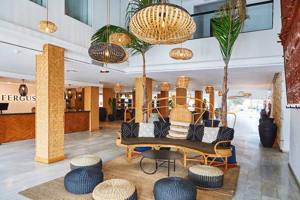 Lobby des Fergus Style Bahamas Hotels mit modernen Möbeln, Palmen und dekorativen Lampen.
