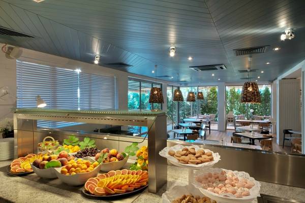 Frühstücksbuffet im Excelsior Hotel mit Obst, Gebäck und Getränken.