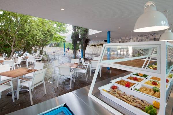 Terrasse des Excelsior Hotels mit Tischen, Stühlen und Essensausgabe