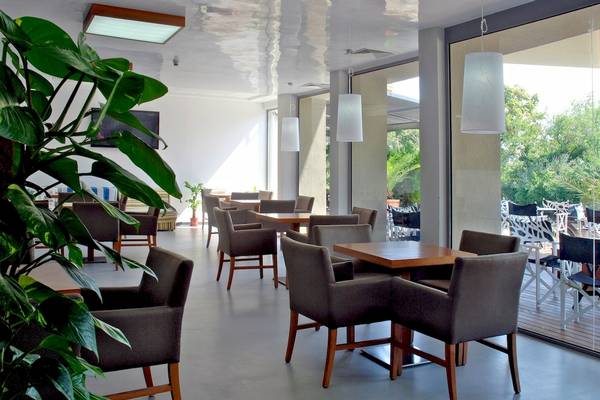 Innenbereich des Excelsior Hotels mit mehreren Esstischen und Stühlen.