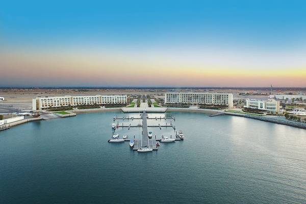 Luftaufnahme der Marina des Barcelo Mussanah Resorts mit mehreren Booten und Gebäuden.