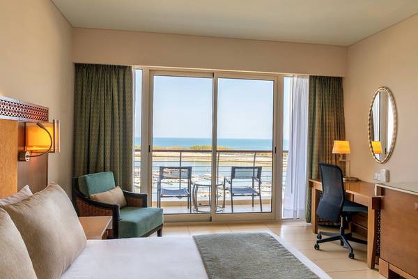 Hotelzimmer mit Meerblick im Barcelo Mussanah Resort mit Balkon, Schreibtisch und Meersicht.