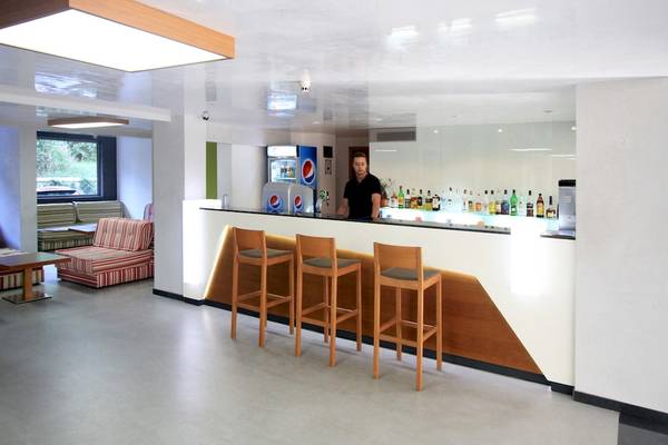Empfangsbereich des Excelsior Hotels mit Bar, Tresen und Barhockern.