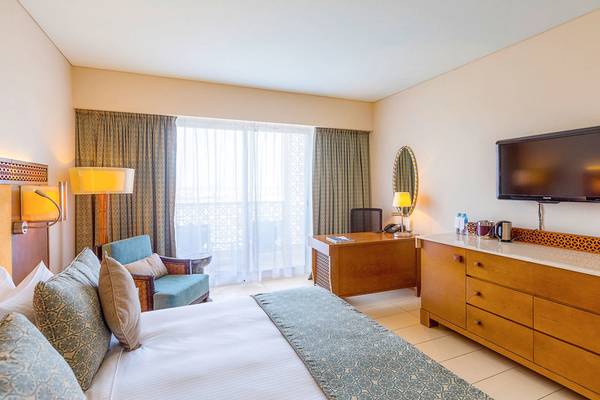Hotelzimmer im Barcelo Mussanah Resort mit Bett, Fernseher und Schreibtisch.