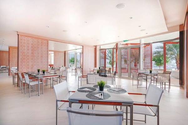Innenbereich des Restaurants im Barcelo Mussanah Resort mit modernen Möbeln und Panoramafenstern.