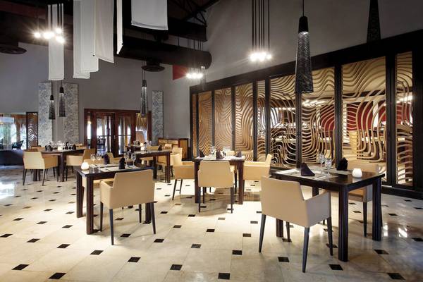 Innenansicht des Restaurants im Grand Palladium Punta Cana Resort & Spa mit geometrischen Mustern an Wänden und Decken.