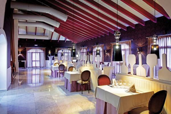 Innenansicht des Restaurants im Grand Palladium Punta Cana Resort mit gedeckten Tischen und Stühlen.