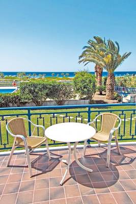 Terrasse im Saint Nicholas Hotel Samos mit Blick auf den Ozean und Palmen