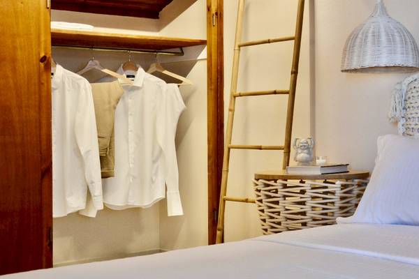 Hotelzimmer im Sunrise Hotel Samos mit Kleiderschrank, Bett und Nachttisch.