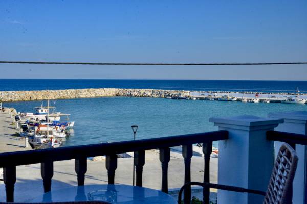 Blick vom Balkon auf den Hafen von Samos mit vielen geparkten Booten und blauem Wasser