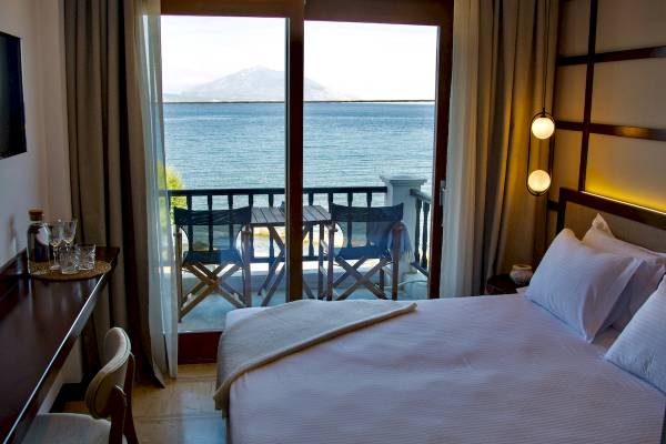 Hotelzimmer im Sunrise Hotel Samos mit Blick auf das Meer und eine Terrasse mit Möbeln.