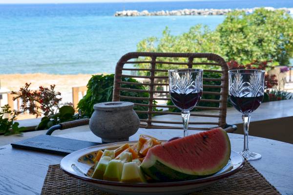 Terrasse mit Meerblick, Obst und Weingläsern auf dem Tisch
