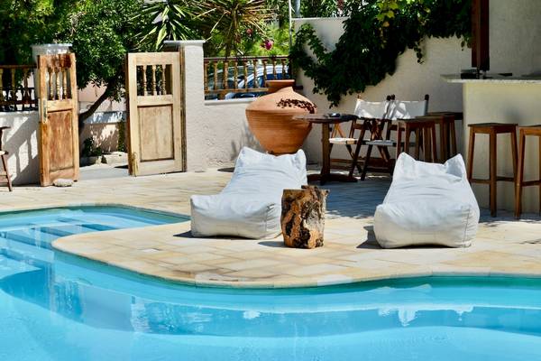 Loungebereich am Pool im Sunrise Hotel Samos mit zwei weißen Sitzsäcken und einem Baumstumpf.