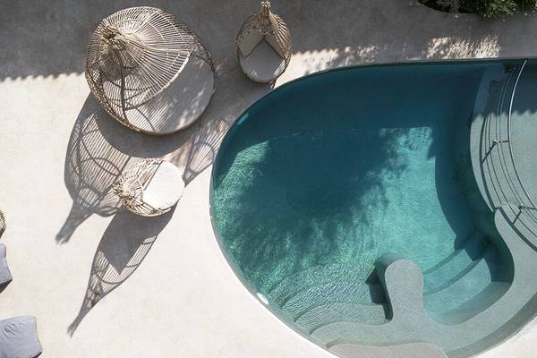Pool und Außenbereich des Samian Mare Hotel mit Rattan-Möbeln und blauem Wasser.