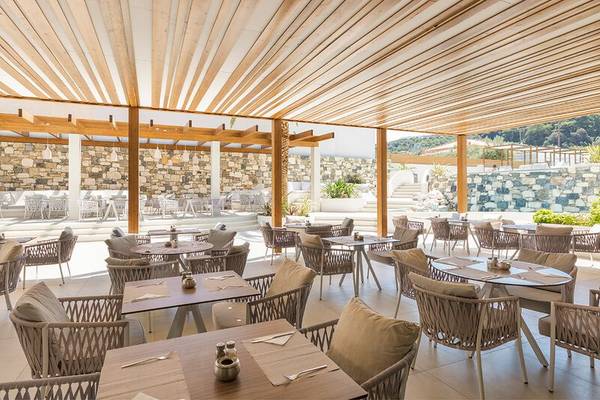 Restaurant des Samian Mare Hotel Suites & Spa mit holzigen Überdachungen und Steinwänden.