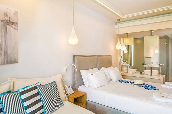 Doppelbettzimmer im Samian Mare Hotel Suites & Spa mit modernem Interieur, zwei Betten und Annehmlichkeiten.