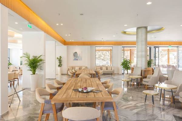 Innenbereich des Erato by Samian Mare Hotels mit hellen Möbeln und Pflanzen.