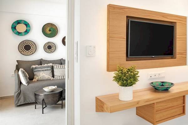Hotelzimmer im Kalidon Panorama mit Wohnzimmer, Fernseher, Dekopflanzen und Korb.