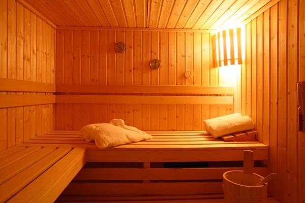Holzsauna im Naxos Resort Beach Hotel mit heller Beleuchtung und Holzbänken.