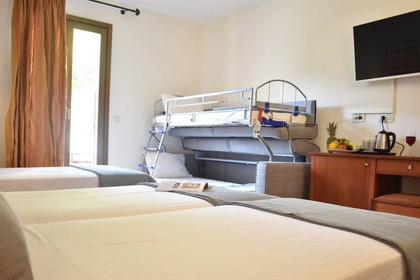 Doppelzimmer mit Etagenbett im Naxos Resort Beach Hotel, das zwei Betten, ein Etagenbett und einen Fernseher zeigt.