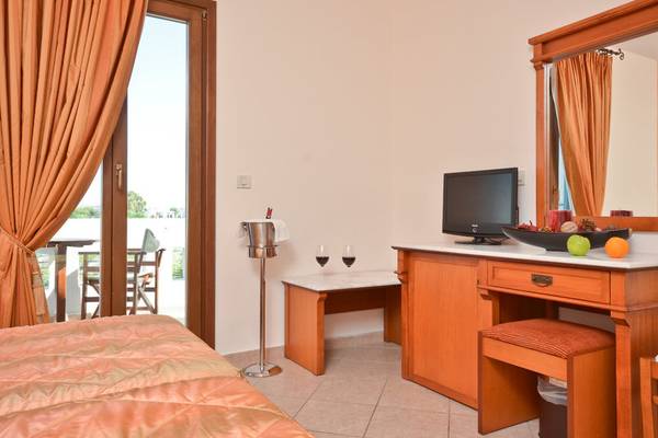 Innenansicht eines Hotelzimmers mit Bett, Schreibtisch und Fernseher am Fenster